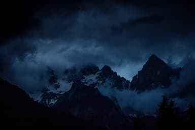 Storm clouds moving through dark alpine peaks